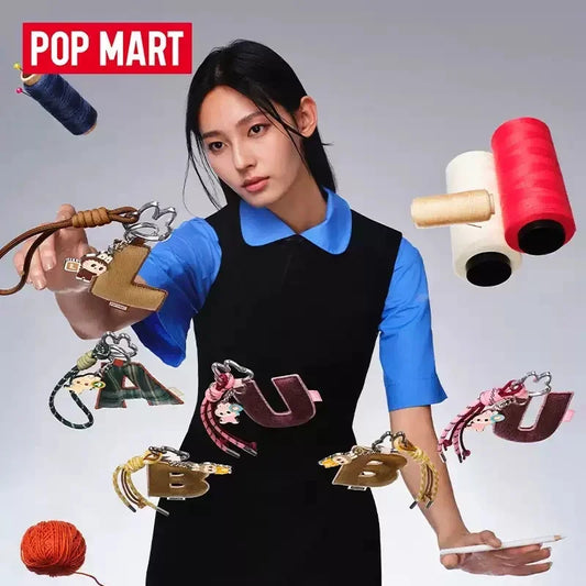 Labubu Pin for Love. Woman holding various keychains with colorful spools of thread in the background, featuring the Pop Mart brand.
