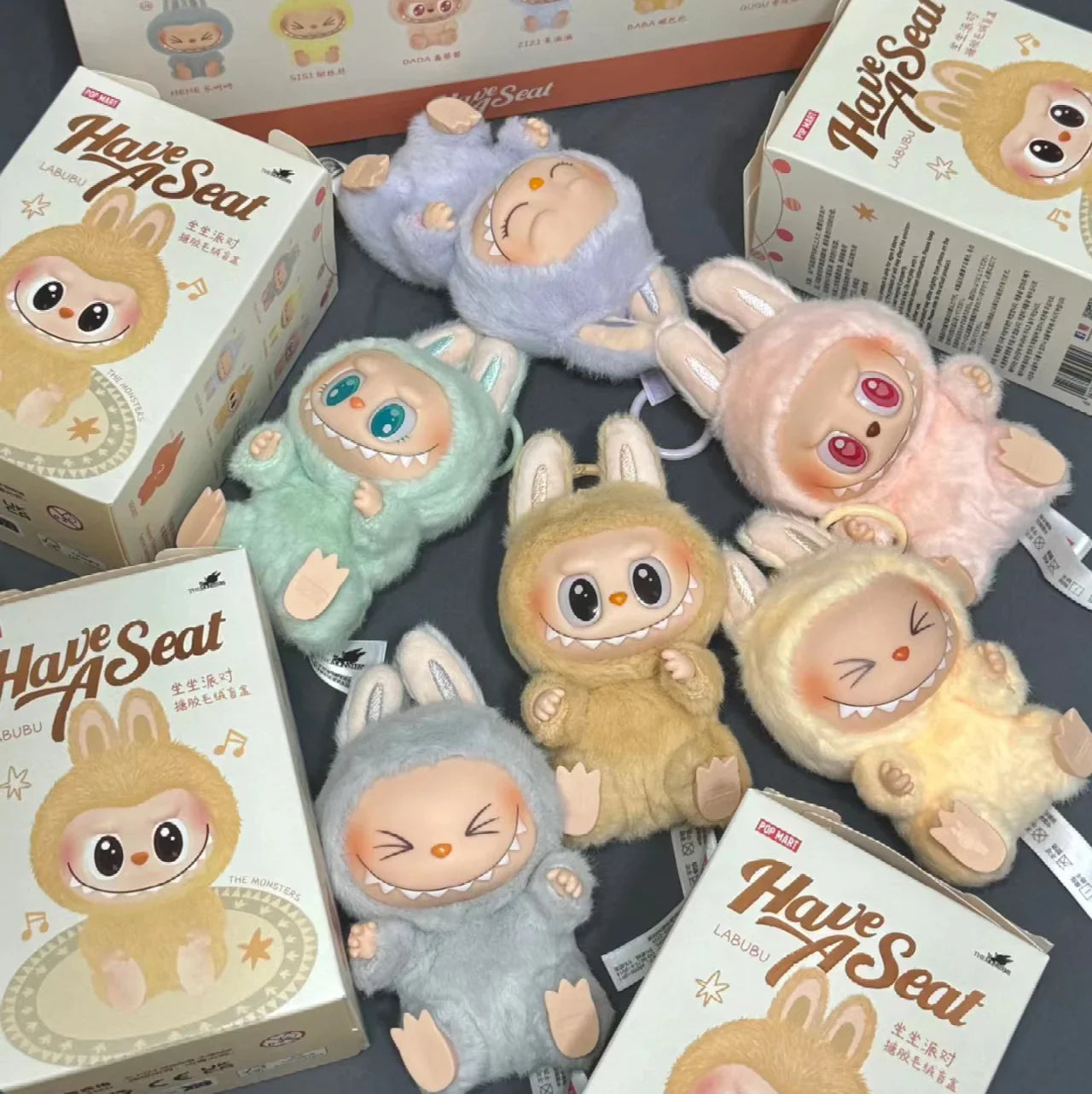 Plush toys Labubus in various colors with 'Have A Seat' boxes around them.