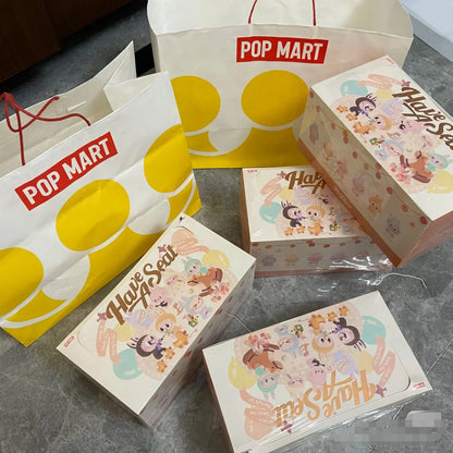 Pop Mart branded packaging with cartoon character boxes on a gray floor.