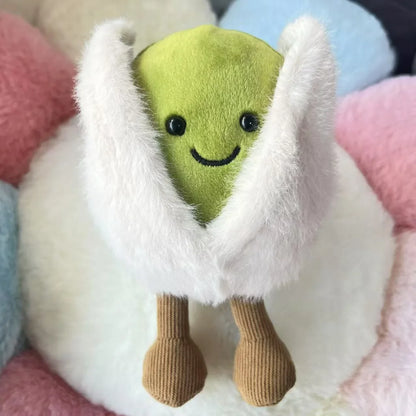 Jellycat pistachio. Green plush toy with a white hood on a soft, multicolored background