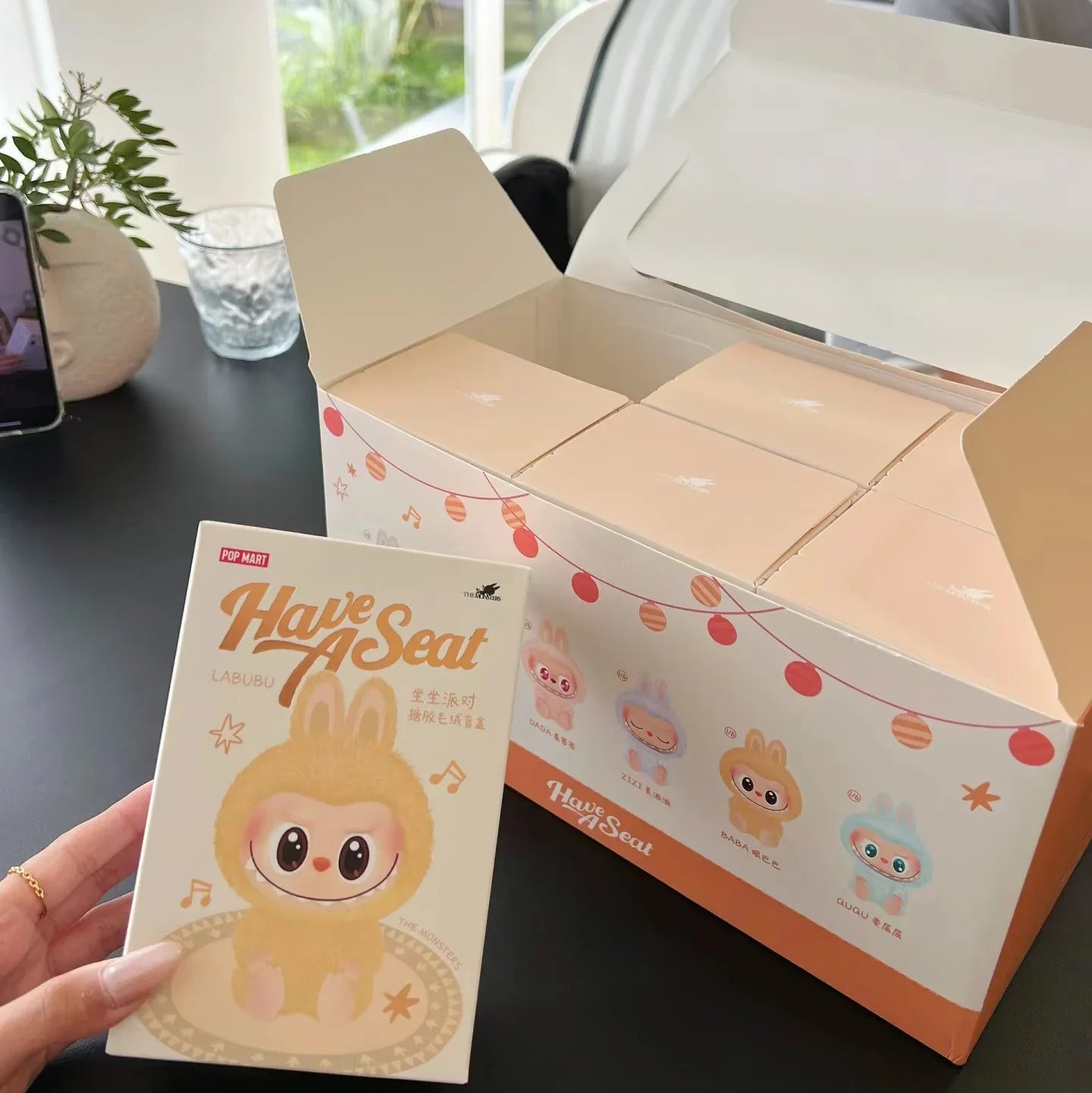 Labubu have a seat. Product packaging with a cute character design on a table.