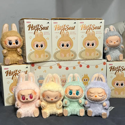 Plush toys Labubus and boxes of 'Have a Seat' on a gray background